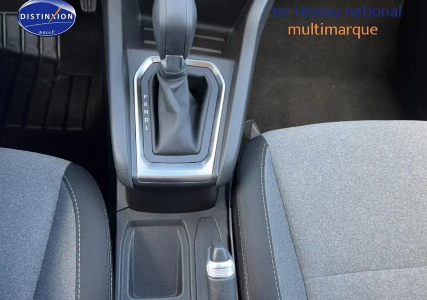 Vue rapprochée de la console centrale et levier de vitesse automatique d'une Renault Clio V gris métal, sièges tissu gris.