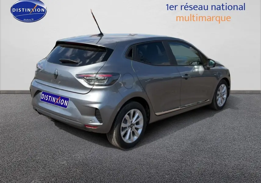 Vue 3/4 arrière droite d'une Renault Clio V gris métal avec becquet et feux arrière LED visibles.