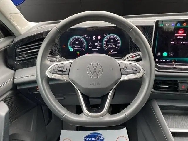 Vue centrée sur le volant cuir noir du Volkswagen Tiguan 2024 avec tableau de bord numérique et écran tactile latéral.