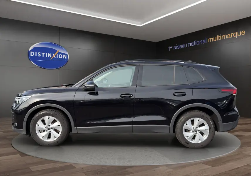 Vue latérale droite d'un Volkswagen Tiguan noir 2024, SUV compact avec jantes alliage et vitres légèrement teintées.