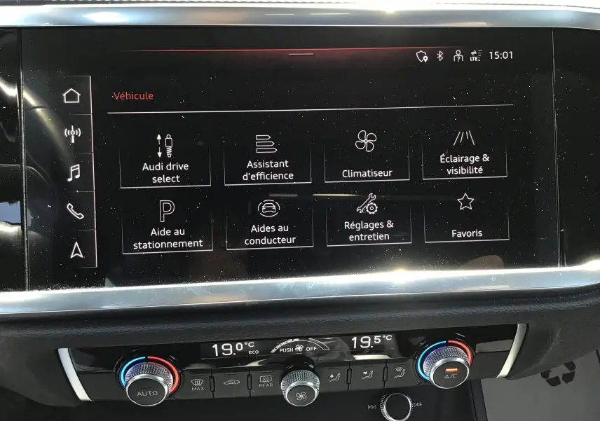 Vue rapprochée de l’écran tactile central et de la console de climatisation d’un Audi Q3 Sportback gris clair métal 2024.