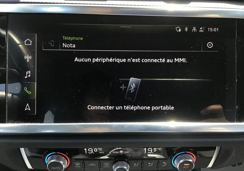 Écran tactile central de l'Audi Q3 Sportback 2024 avec affichage Bluetooth et commandes climatisation en dessous.