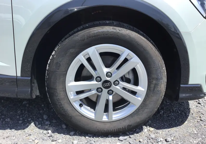 Gros plan sur la roue avant droite d’un Audi Q3 Sportback gris clair métal avec jante alliage 17 pouces.