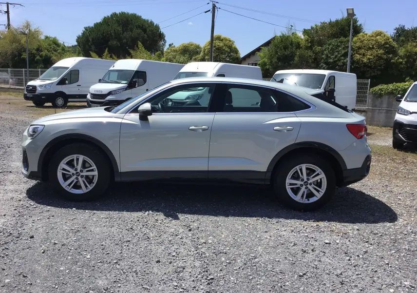 Audi Q3 Sportback gris clair métal, vue de profil côté gauche, soulignant la silhouette coupé et les jantes 17 pouces.