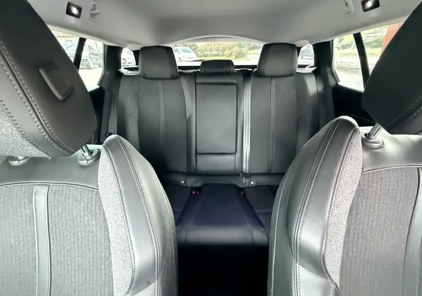 Vue intérieure arrière montrant les sièges noirs en tissu et cuir d'une Peugeot 308 SW 2018.
