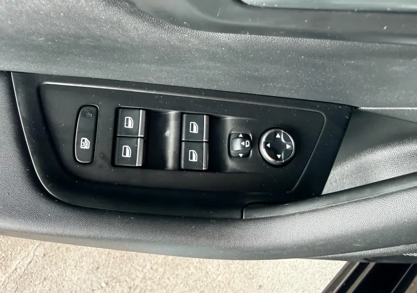 Panneau de commandes des vitres et rétroviseurs côté conducteur de la Peugeot 308 SW noire de 2018.