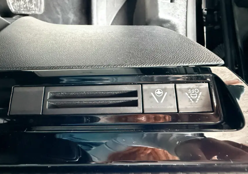 Gros plan sur les boutons de commande noirs du système d'aide à la conduite dans une Peugeot 308 SW noir métal.