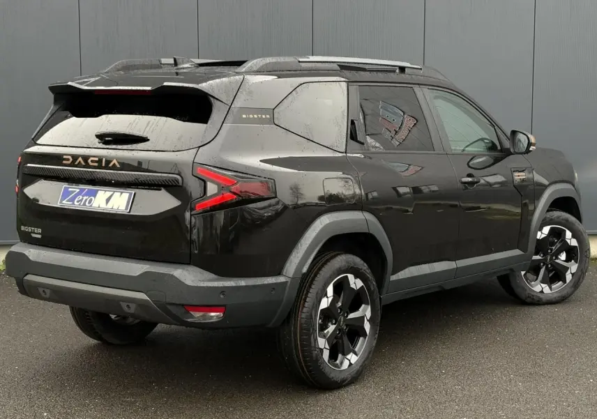 Vue 3/4 arrière droit du Dacia Bigster noir nacré avec hayon électrique et jantes alliage noires diamantées.