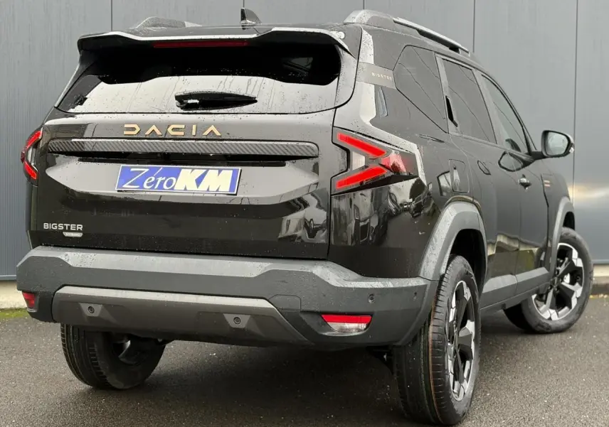 Vue 3/4 arrière droite du Dacia Bigster noir nacré avec hayon électrique et jantes alliage noires diamantées.