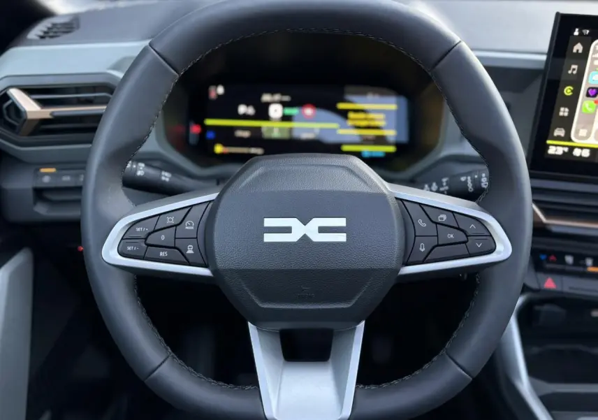 Vue rapprochée du volant noir avec commandes intégrées et combiné numérique du tableau de bord du Dacia Bigster 2026.