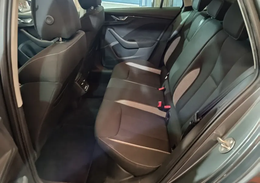 Vue intérieure arrière côté droit du Skoda Kamiq gris clair 2024, banquette 3 places avec sièges noirs et inserts gris.