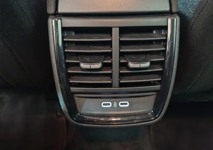 Gros plan sur la sortie d'air arrière noire avec commandes et deux ports USB-C du Skoda Kamiq gris clair 2024.
