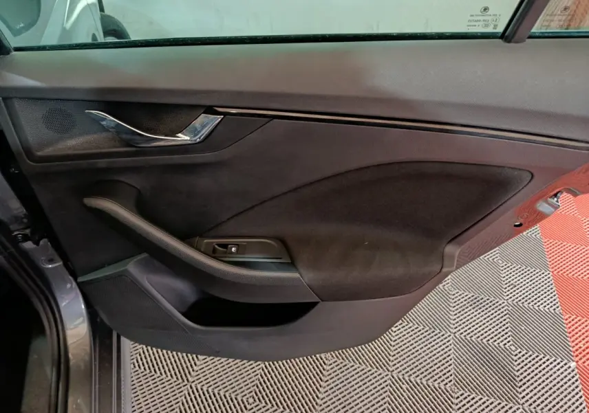 Vue intérieure côté gauche de la porte avant gris clair du Skoda Kamiq 2024 avec poignée chrome et commande de vitre.