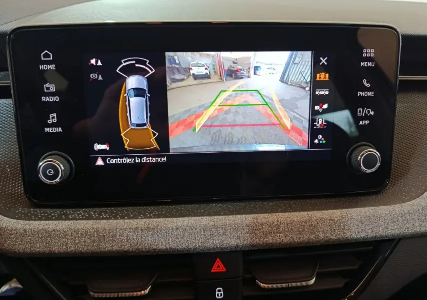 Écran tactile central du Skoda Kamiq gris clair 2024 montrant la caméra de recul avec guidage coloré.