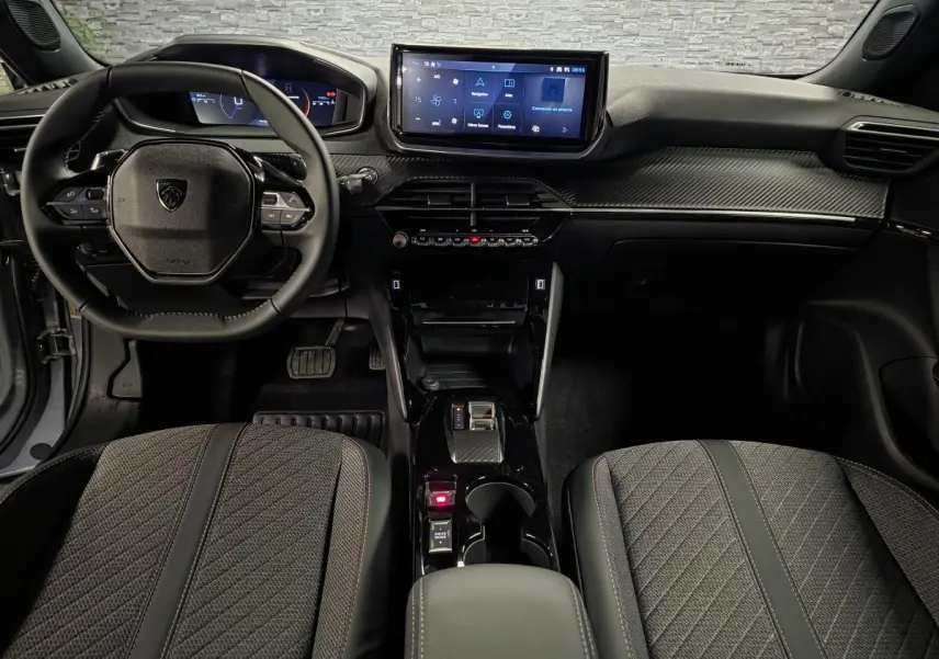 Vue intérieure avant du Peugeot 2008 gris 2025, avec tableau de bord numérique et écran tactile central.