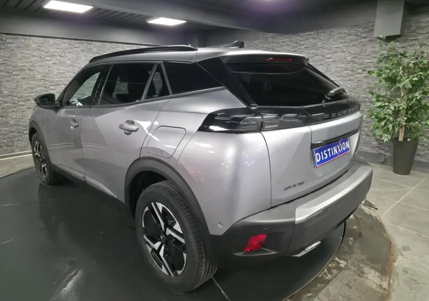 Vue 3/4 arrière droite d'un Peugeot 2008 gris métallisé avec toit noir et feux arrière LED distinctifs.