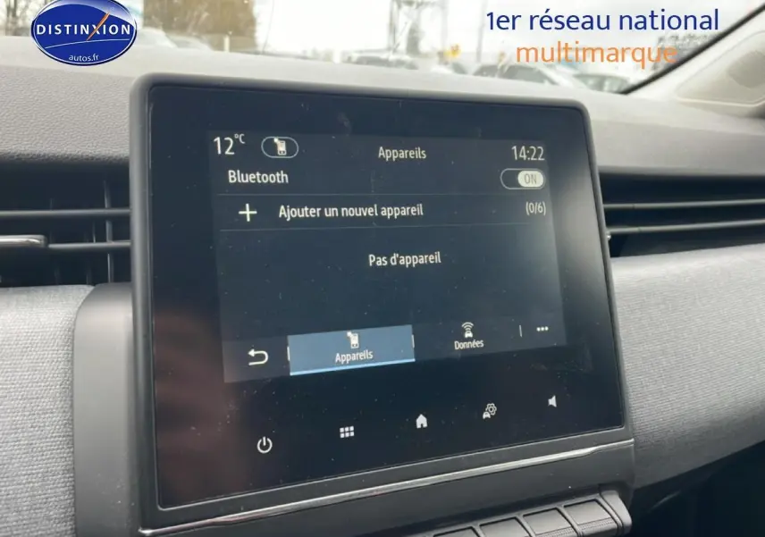 Écran tactile central de la Renault Clio V blanche, vue intérieure côté passager avec tableau de bord gris.