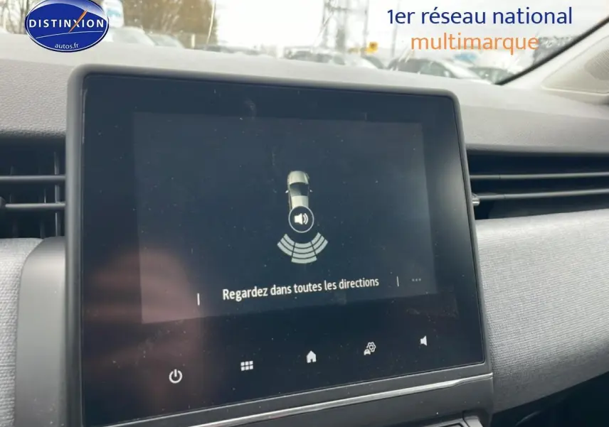 Écran tactile central affichant l'aide au stationnement dans l'habitacle d'une Renault Clio V blanche.