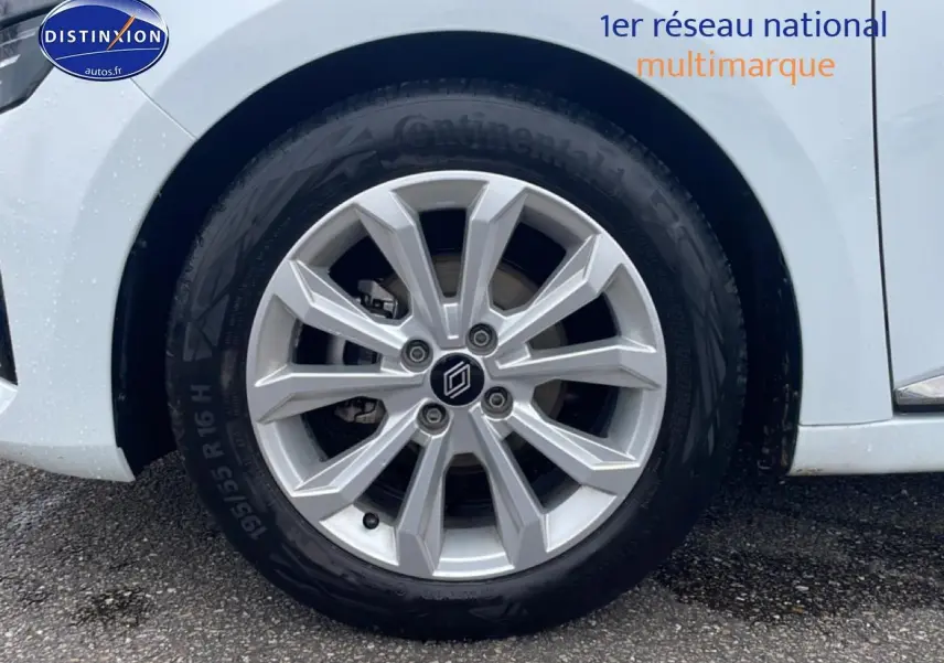 Gros plan sur la roue avant droite d'une Renault Clio V blanche avec jante alliage 16 pouces.