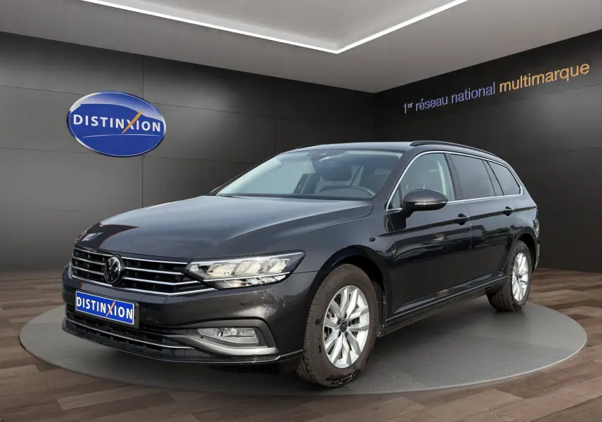 Volkswagen Passat break gris foncé vue 3/4 avant droit avec phares LED et jantes alliage en showroom.