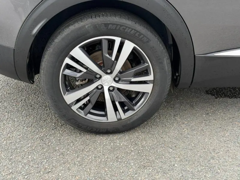 Gros plan sur la roue avant droite du Peugeot 3008 Hybride Rechargeable gris Titane avec jante alliage bicolore.