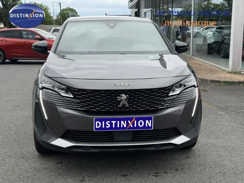 Vue avant d'un Peugeot 3008 Hybride Rechargeable gris titane avec calandre noire et feux LED distinctifs.