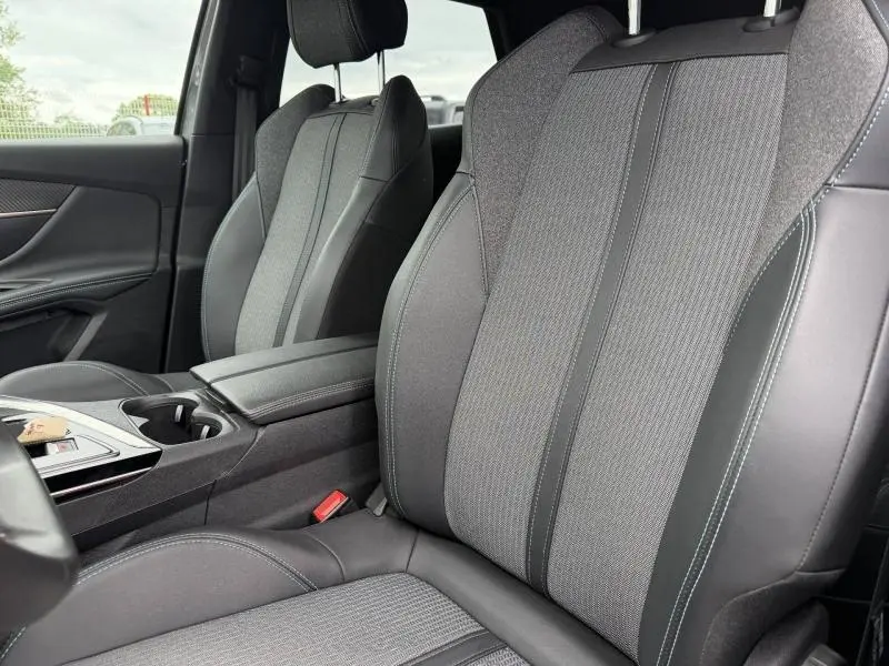 Vue rapprochée des sièges avant en tissu et cuir gris à l'intérieur du Peugeot 3008 Hybride Rechargeable 2024.