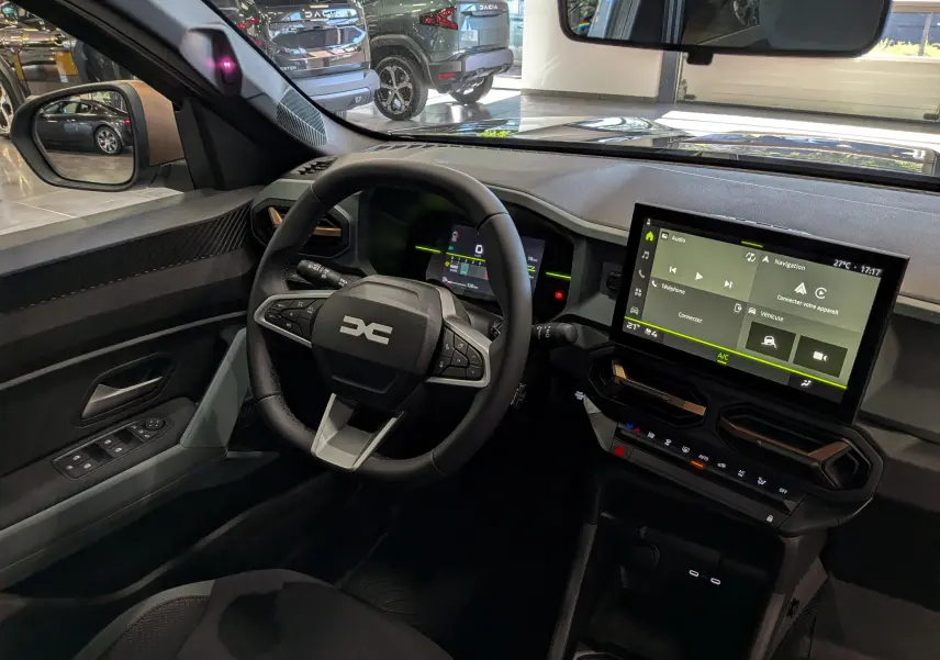 Vue intérieure côté conducteur du Dacia Duster 2026 avec tableau de bord numérique et écran tactile central.