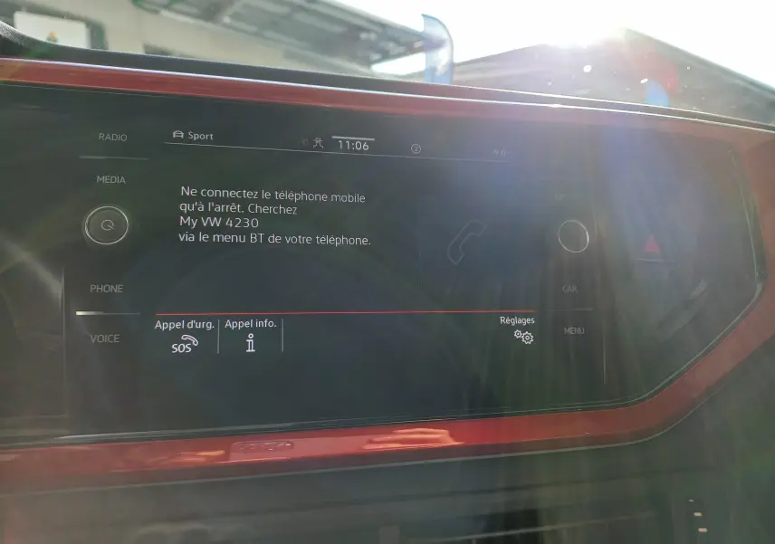 Vue intérieure du tableau de bord de la Volkswagen Polo GTI 2024, écran tactile avec cadre rouge et commandes tactiles.