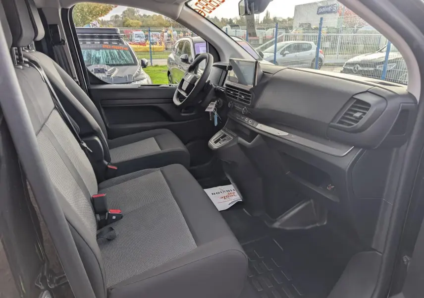Intérieur avant du Peugeot Expert Fourgon noir 2025, vue côté conducteur montrant sièges tissu bi-ton et tableau de bord moderne.