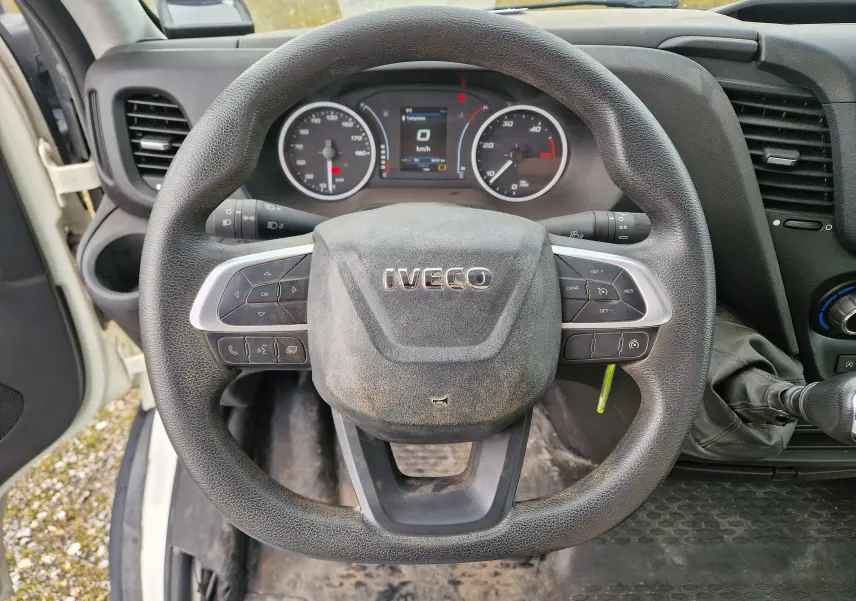 Vue intérieure centrée sur le volant noir de l'Iveco Daily Chassis Cabine blanc avec tableau de bord et commandes visibles.