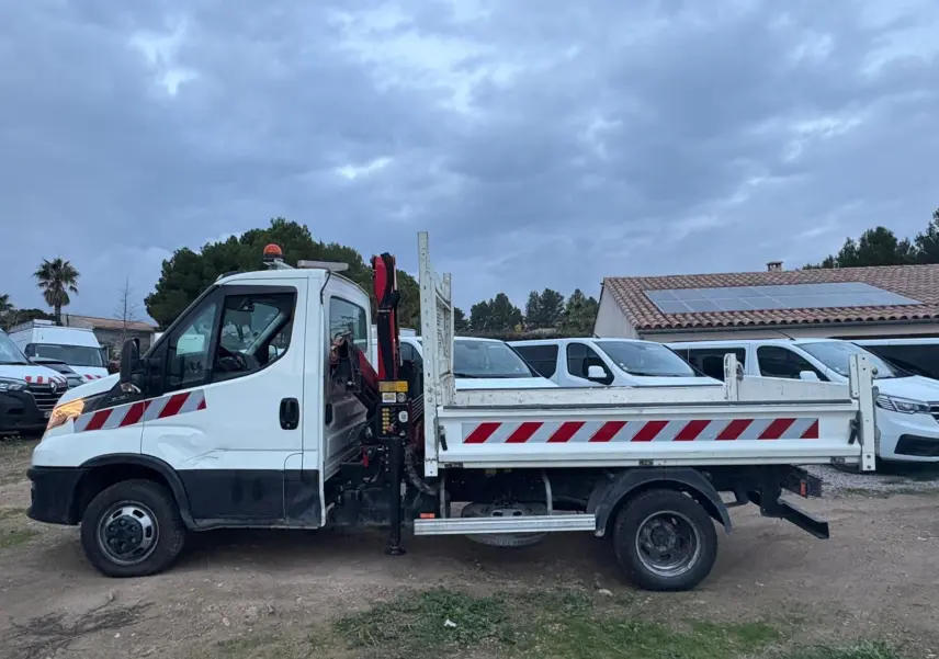 IVECO Daily Chassis Cabine blanc vu de profil gauche avec benne et grue Palfinger rouge et stabilisateurs déployés.