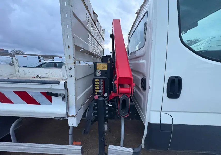 Vue rapprochée de profil droit montrant la cabine blanche et la grue rouge Palfinger entre cabine et benne blanche.