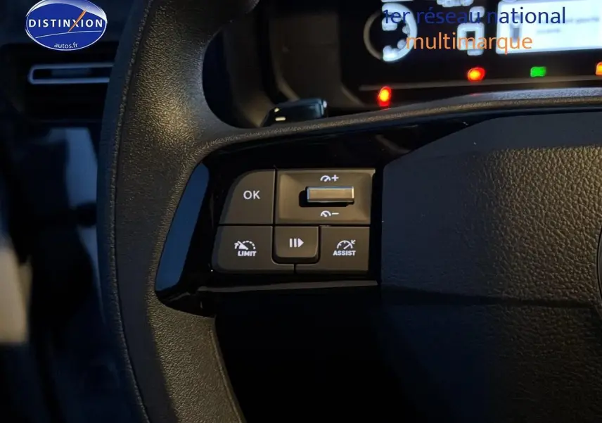 Gros plan sur les commandes multifonctions à gauche du volant du Citroën Berlingo Fourgon blanc, tableau de bord en arrière-plan.