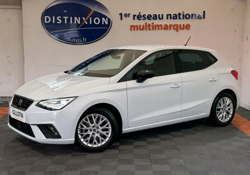 SEAT Ibiza 1.0 TSI 110 FR blanc vue 3/4 avant droit, jantes alliage et phares LED allumés.