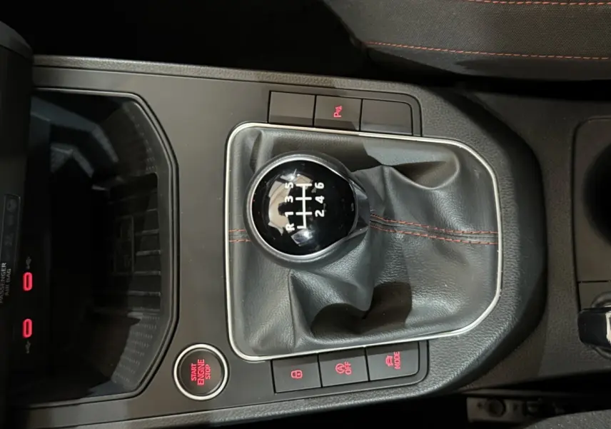 Vue rapprochée du levier de vitesses manuel noir avec coutures rouges dans une SEAT Ibiza blanche 2024.