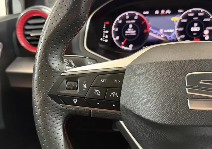 Gros plan sur le volant cuir et alu de la SEAT Ibiza 1.0 TSI 110 FR 2024 avec commandes multifonctions et tableau de bord numérique.