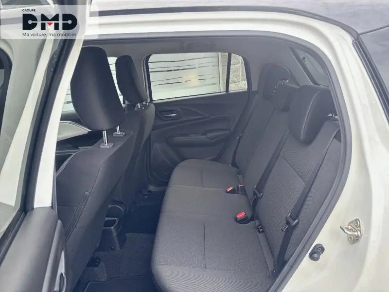 Vue intérieure côté gauche montrant la banquette arrière en tissu gris foncé de la Suzuki Swift 2025 blanche.