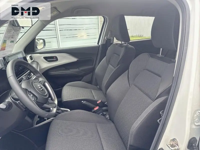 Vue intérieure côté gauche montrant les sièges avant en tissu gris et le tableau de bord d'une Suzuki Swift blanche 2025.