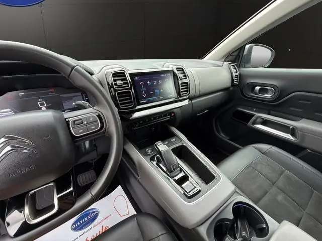 Vue intérieure côté conducteur du Citroën C5 Aircross gris acier, montrant le tableau de bord numérique et la console centrale moderne.