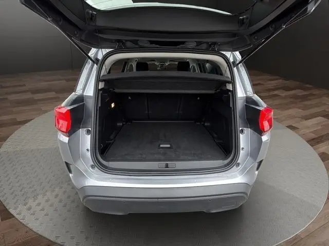 Vue arrière ouverte du coffre d'un Citroën C5 Aircross gris acier, montrant l'espace de chargement vide et la plage arrière.