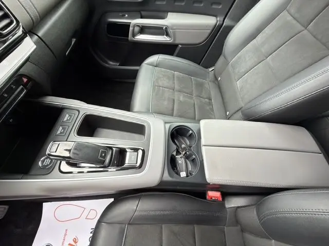 Vue intérieure centrée sur la console centrale et sièges gris tissu et cuir du Citroën C5 Aircross 2022.