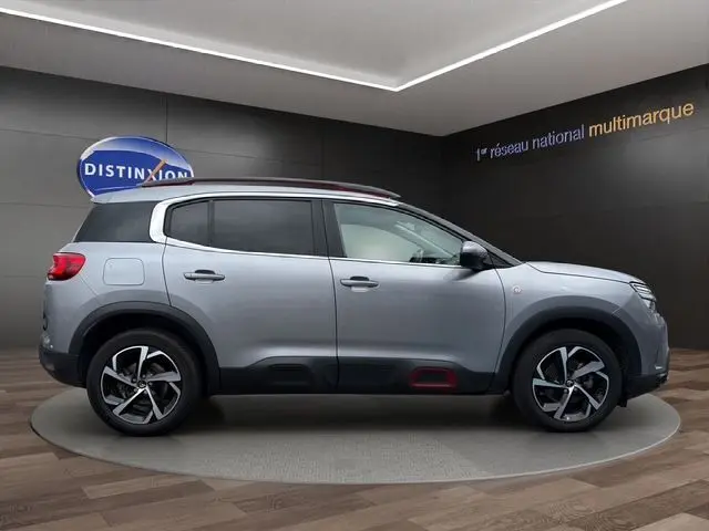 Vue de profil droit du Citroën C5 Aircross gris acier 2022 avec jantes alliage et détails rouges sur bas de caisse.