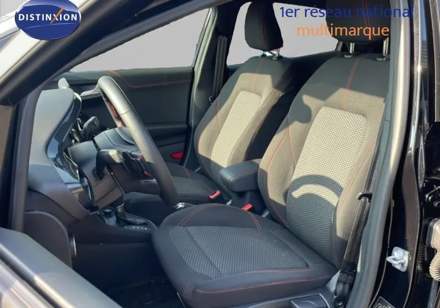 Intérieur avant du Ford Puma noir agate métal 2023, sièges tissu avec surpiqûres rouges et volant multifonction.