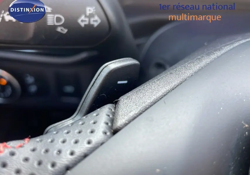 Gros plan sur le volant perforé noir avec palettes de changement de vitesse dans l’habitacle du Ford Puma noir Agate Metal 2023.