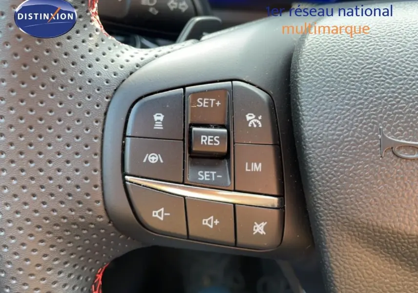 Gros plan sur les commandes de régulateur et volume du volant perforé d’une Ford Puma noir agate 2023.