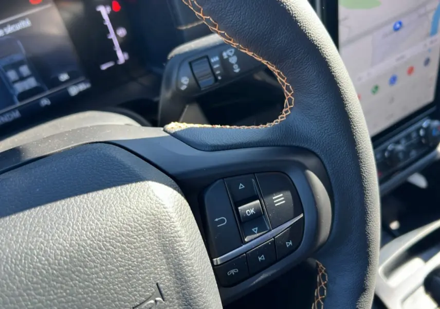 Gros plan sur le volant cuir noir avec surpiqûres marron et commandes multifonctions du Ford Ranger 2026.