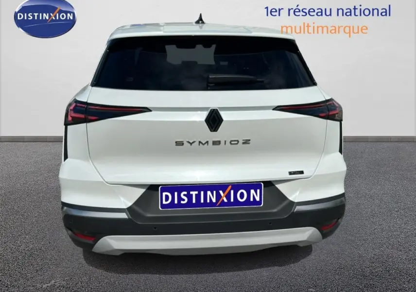Vue arrière d'une Renault SYMBIOZ blanche, version E-Tech full hybrid 145 Iconic, avec feux arrière LED et logo central noir.