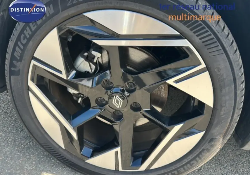 Gros plan sur la jante alliage 19 pouces noire et argentée d'une Renault SYMBIOZ blanc, version E-Tech full hybrid 145 Iconic.