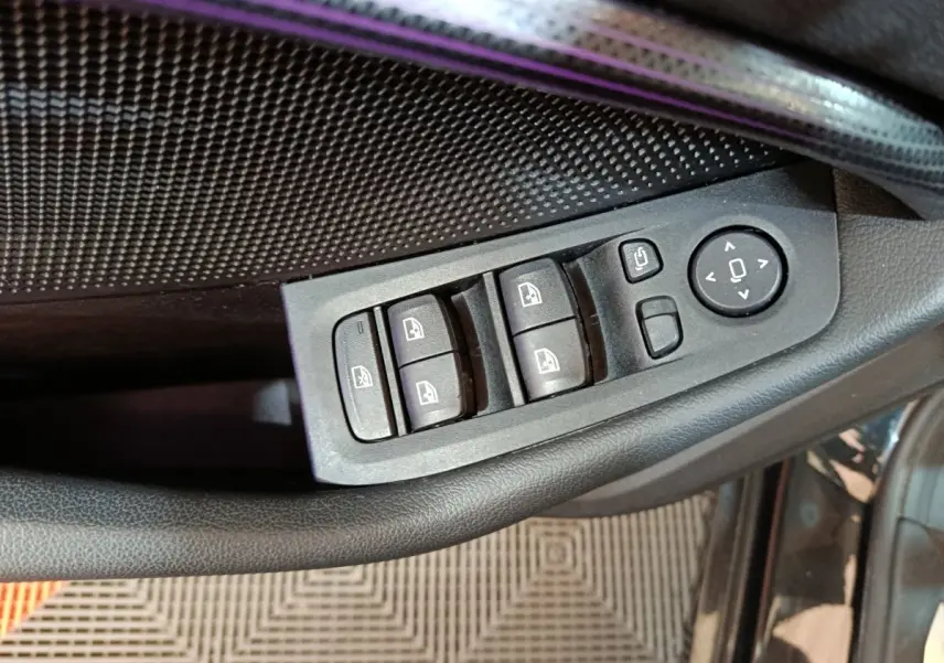 Gros plan sur les commandes de lève-vitres et rétroviseurs côté conducteur d’une BMW Série 1 noire 118i Edition Sport.